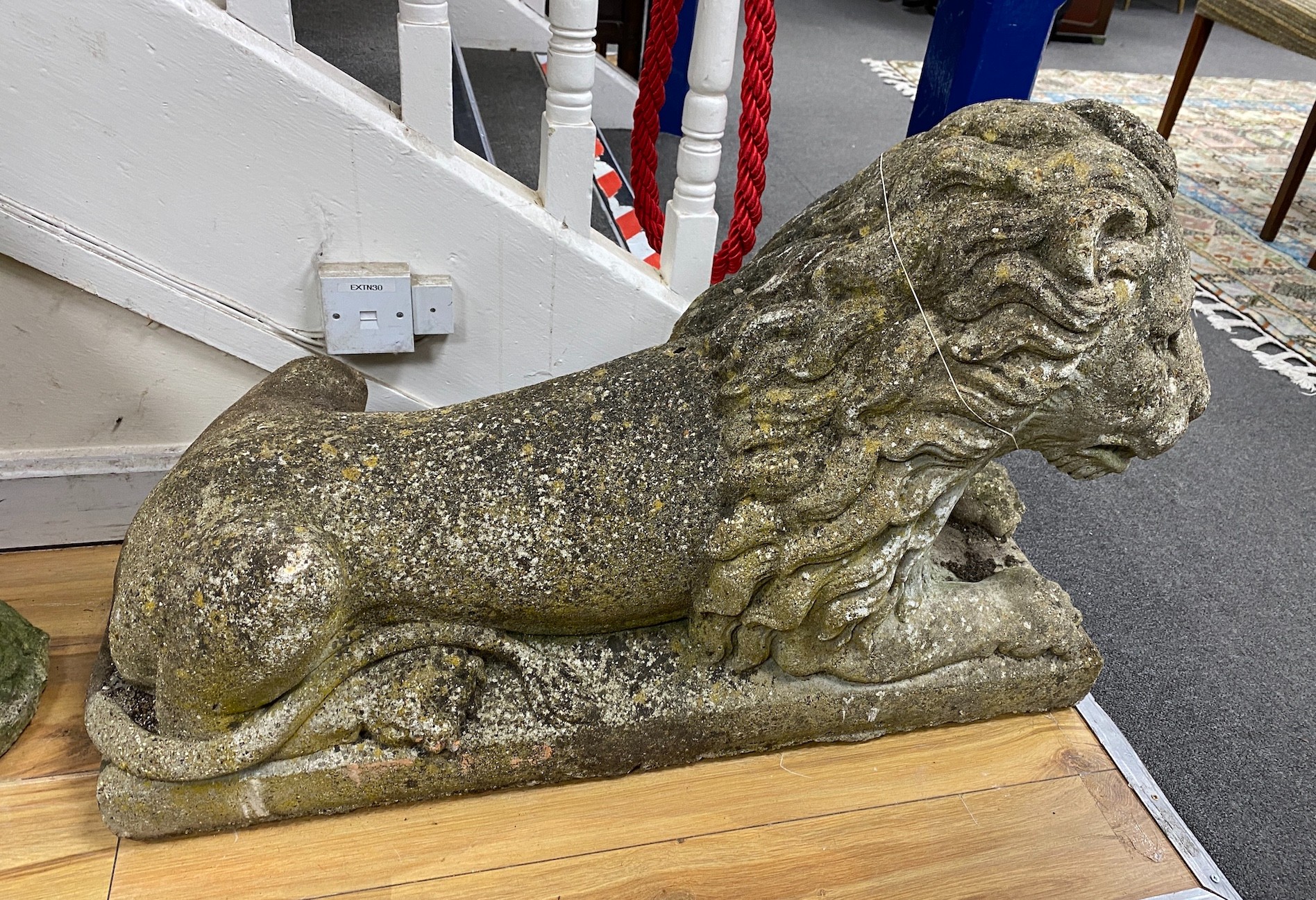 A large reconstituted stone recumbent lion garden ornament, length 91cm, depth 33cm, height 60cm